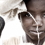 a little boy selling coconuts in Sierra Leone